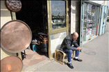 Yossi Saadoun sits at the entrance to the souvenir shop