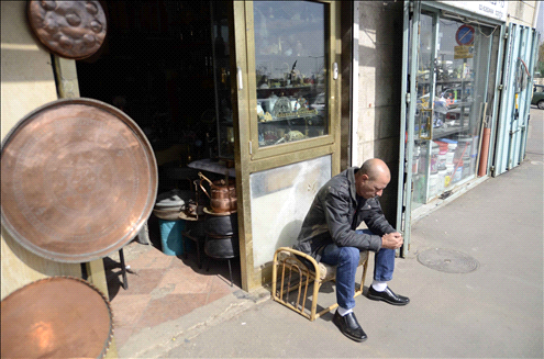 Yossi Saadoun sits at the entrance to the souvenir shop